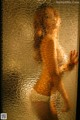 A picture of a naked woman standing in front of a window.