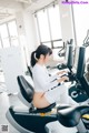 A woman sitting on a stationary bike in a gym.