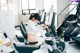 A woman sitting on a stationary bike in a gym.