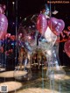 A group of people standing in a room filled with balloons.