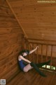 A woman sitting on a wooden deck in a blue dress.