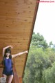 A woman in a blue bathing suit standing on a balcony.