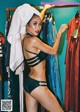 A woman in a black bikini standing in front of a rack of clothes.