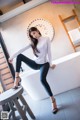 A woman sitting on top of a bathtub in a bathroom.