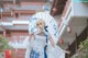 A woman in a white dress holding an umbrella.