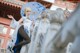 A woman in a white dress holding an umbrella.