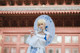 A woman in a white dress holding an umbrella.