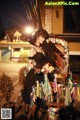 A woman in a black dress holding a bouquet of flowers.