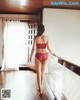 A woman in a red lingerie walking down a hallway.