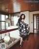 A woman in a black and white kimono standing on a balcony.