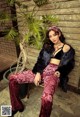 A woman sitting on a chair next to a plant.