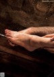 A woman's feet being washed in a bathtub with a brush.