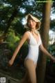 A woman in a white bathing suit and a straw hat.