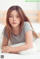 A woman laying on top of a white bed.