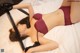 A woman laying on a bed wearing a red bra and black lingerie.