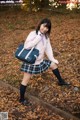 A woman in a school uniform is posing for a picture.