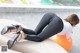 A woman in black leggings and high heels laying on an orange ball.