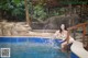 A woman in a white bikini sitting in a swimming pool.