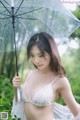 A woman in a white lingerie holding an umbrella.