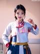 A woman in a blue and white hanbok is posing for a picture.