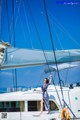 A woman standing on the deck of a sailboat.