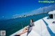 A woman sitting on the deck of a boat in the water.