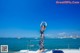 A woman standing on the deck of a boat in the ocean.