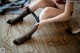 A woman in a red bra and black stockings sitting on the floor.