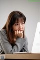 A woman sitting at a desk with a laptop computer.