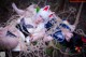 A couple of women laying on top of a forest floor.