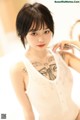 A woman with a tattoo on her chest is posing for a picture.