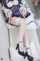 A woman in a maid outfit laying on a couch.